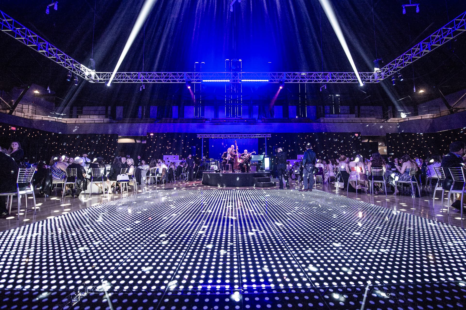 LED-lit dance floor with live band performing and guests dancing at gala celebration